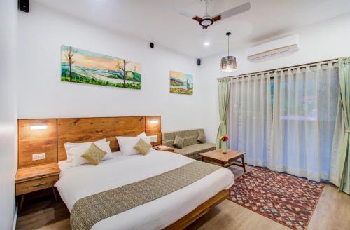 a hotel room with a bed and a chair at Hotel Malas in Panchgani