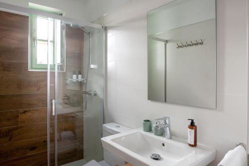 baño blanco con ducha y lavamanos en Hommyhome Teodosio, en Sevilla