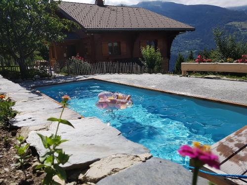 - 2 personnes dans une piscine à l'arrière-cour dans l'établissement Chalet Le Paradou, à La Côte-dʼAime