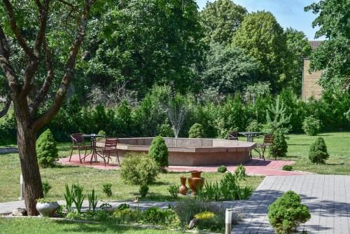 un jardín con un banco y una mesa en "Trakaitis" Entire Deluxe Villa, en Trakai