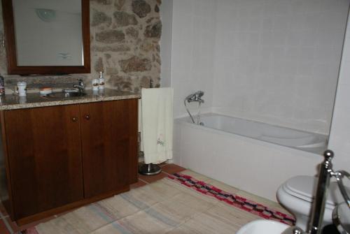 a bathroom with a tub and a sink and a toilet at Casa Real Danaia in Germil