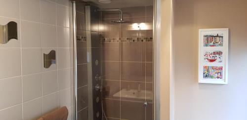 La salle de bains est pourvue d'une douche avec une porte en verre. dans l'établissement Le Central, à Honfleur