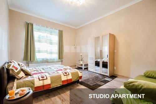 ブダペストにあるBpR Corvin Cosy Apartmentsのベッドルーム(ベッド1台、ソファ付)