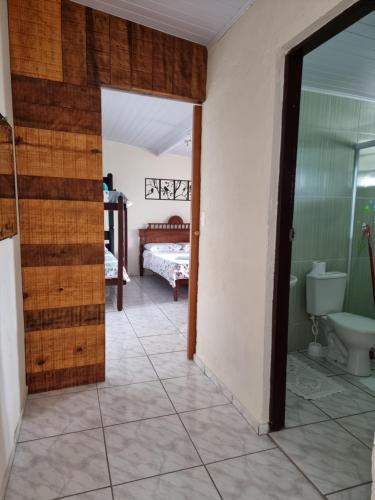a room with a bathroom with a toilet and a bedroom at Tranquilidade e vista privilegiada in Ilhabela