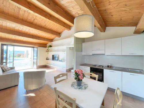 cocina y sala de estar con mesa blanca y sillas en Cà Vincenzona, Wellness Area, en Faenza