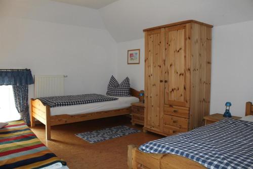 een slaapkamer met 2 bedden en een houten kast bij Ferienhof " Dat grode Gulfhuus" in Tossens