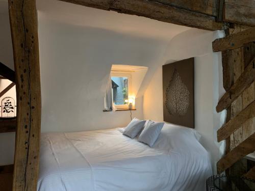 a white bed in a bedroom with a window at L'Ecole des Demoiselles in Honfleur