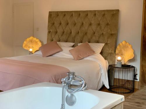 a bedroom with a large bed and a sink at L'Ecole des Demoiselles in Honfleur