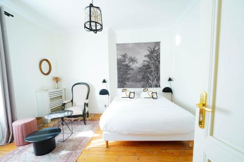 a white bedroom with a bed and a desk at B&B La Maison Galiène in Bordeaux