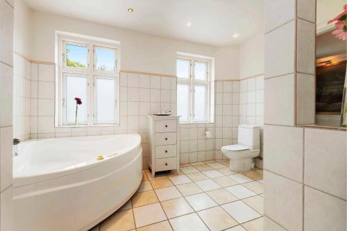 a white bathroom with a tub and a toilet at Brigsted B&B in Horsens