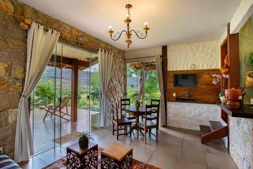 a kitchen and living room with a table and chairs at Sitio Jatoba/Lapinha da Serra in Santana do Riacho