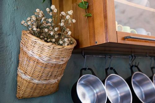 a basket with flowers in it next to a cabinet at Sitio Jatoba/Lapinha da Serra in Santana do Riacho