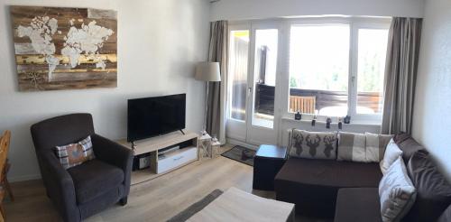 a living room with a couch and a television at Choucas A16 in Crans-Montana