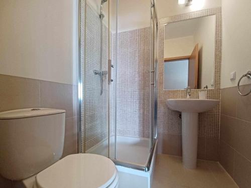 a bathroom with a shower and a toilet and a sink at Apartamento Canada Formosa Cabanas Beach by Your Home Algarve in Cabanas de Tavira