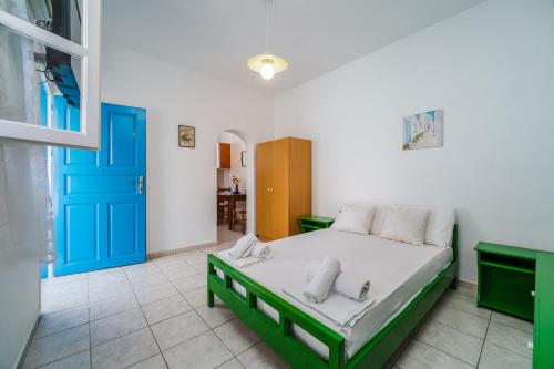 a bedroom with a bed and a blue door at Ancient Thera Apartments in Kamari