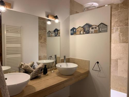a bathroom with two sinks and a mirror at L'Ecole des Demoiselles in Honfleur