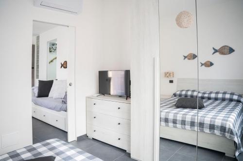 ein Schlafzimmer mit zwei Betten und einem Fernseher und einem Spiegel in der Unterkunft 021 - Casa Ponente con Terrazzo - CENTRO città, Carruggio e Mare BAIA DEL SILENZIO a 500 m in Sestri Levante