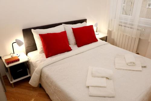 a bedroom with a large bed with red pillows at Apartment Elena 1, Zagreb City with garage in Zagreb