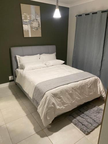 a bedroom with a large bed with white sheets at The Blyde Crystal lagoon, Pretoria (2 beds) in Pretoria