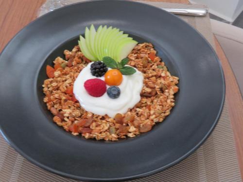 a black plate of food with fruit and whipped cream at Hotel Sun in North Nicosia
