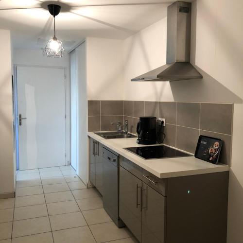 a kitchen with a sink and a stove at Aux couleurs d’Ardèche in Vallon-Pont-dʼArc