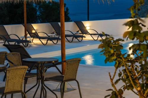 a group of chairs and tables next to a pool at Ancient Thera Apartments in Kamari