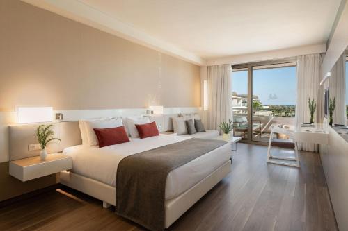 a large bedroom with a large bed and a balcony at Avra Imperial Hotel in Kolymvari