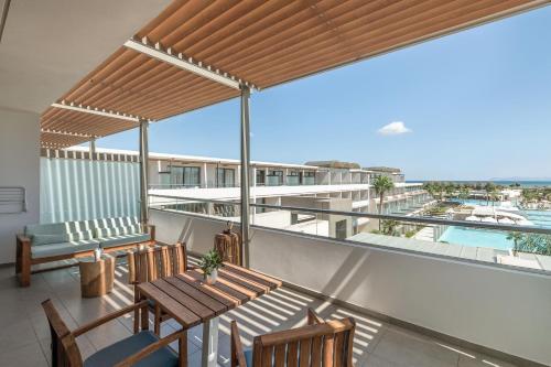 a balcony with a table and chairs and a view at Avra Imperial Hotel in Kolymvari