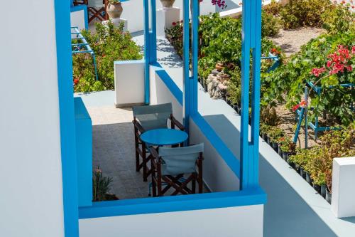 a patio with a table and chairs in a garden at Ancient Thera Apartments in Kamari