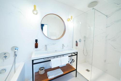a white bathroom with a sink and a mirror at B&B La Maison Galiène in Bordeaux