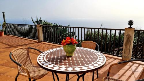 a table with a vase of flowers on a deck at Neólida in Puntallana