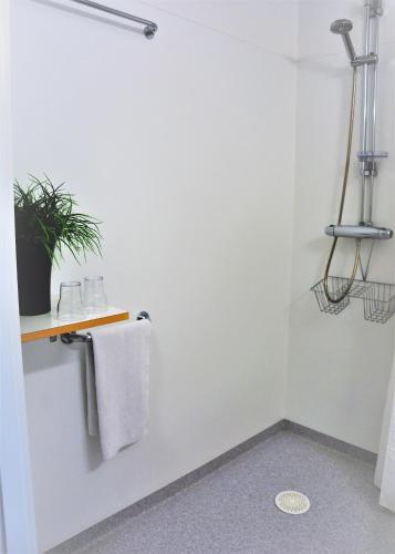 a bathroom with a towel hanging on a wall at Katrinebergs Folkhögskola B&B in Vessigebro