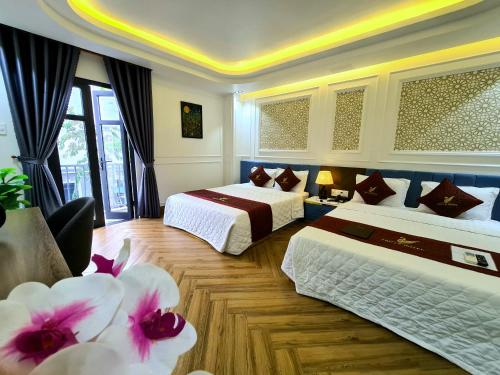 ein Hotelzimmer mit 2 Betten und Blumen darin in der Unterkunft THƯ LÊ Hotel in Cao Lãnh