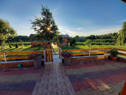 a group of benches in a garden with a tree at Gólya-Tó Vendégház in Vajdácska