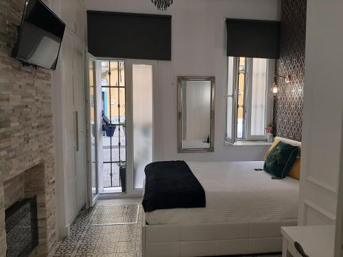 a bedroom with a bed and a fireplace at LA SUITE DEL CONDE LUXURY SUITES in Seville