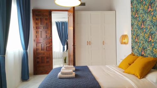 a bedroom with a bed with towels on it at Sherryflat Teatro in Jerez de la Frontera