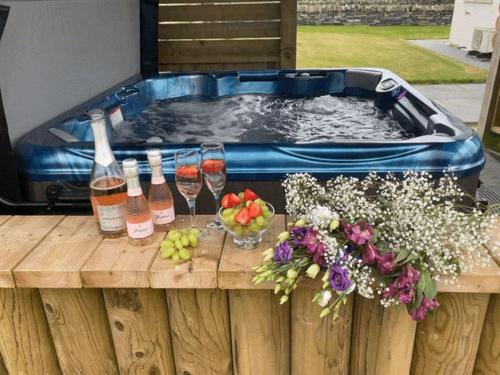 a hot tub with drinks and wine bottles on a wooden table at Taylor's Rest in Toab