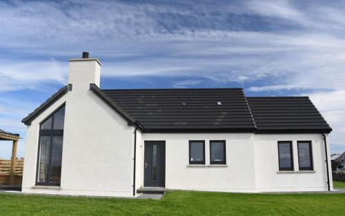 a white house with a black roof at Taylor's Rest in Toab