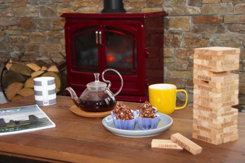 a table with cupcakes and a teapot and a book at Taylor's Rest in Toab