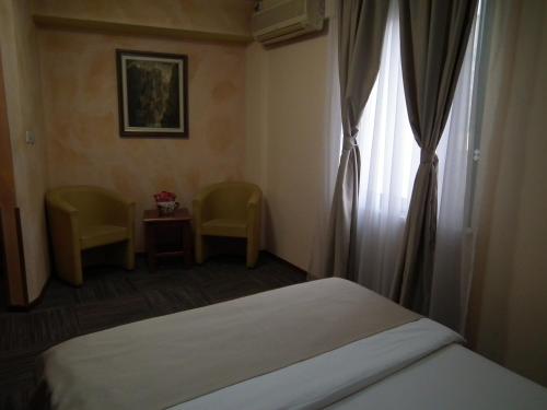 a hotel room with a bed and a window at Hotel Kerber in Podgorica