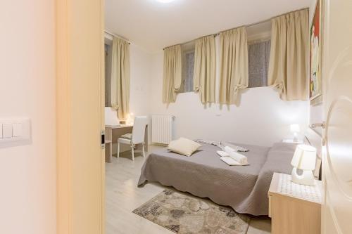 biały pokój z łóżkiem i biurkiem w obiekcie Zanardelli 1 Apartment by Wonderful Italy w mieście Salò