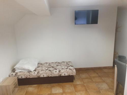 sypialnia z łóżkiem i telewizorem na ścianie w obiekcie ubytovanie FRENAT w mieście Kúty
