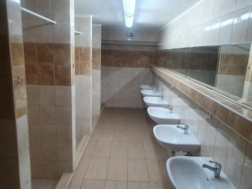 łazienka z rzędem białych umywalk i luster w obiekcie ubytovanie FRENAT w mieście Kúty