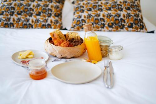 a table with a plate of food and a basket of bread at B&B La Maison Galiène in Bordeaux