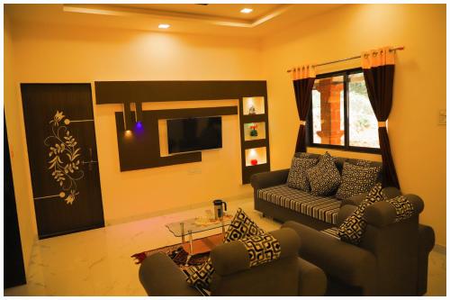 a living room with a couch and a table at INFINITY HOUSE in Mahabaleshwar