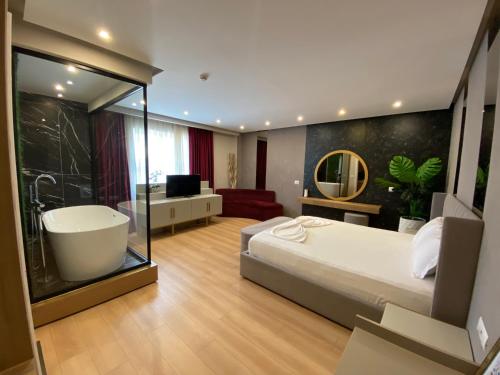um quarto com uma cama grande e uma banheira em Hotel Colis em Tirana
