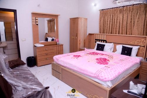 a bedroom with a large bed with pink sheets at Hotel Inn Hyderabad in Hyderabad