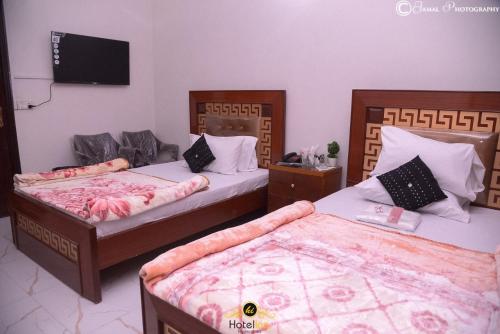 a bedroom with two beds and a flat screen tv at Hotel Inn Hyderabad in Hyderabad