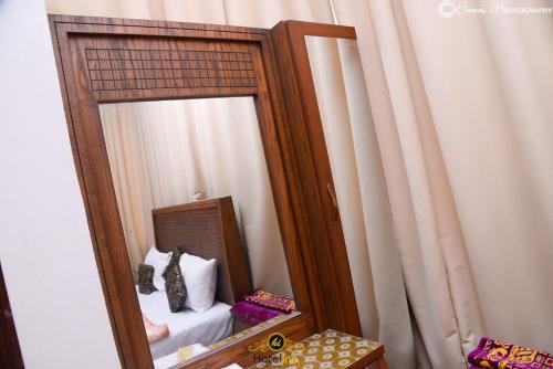 a mirror with a bed in a room at Hotel Inn Hyderabad in Hyderabad