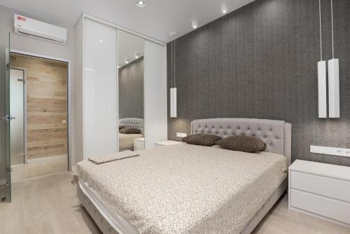 een slaapkamer met een groot bed en een spiegel bij 45 Pearl 2-bedrooms Apartment with Terrace in Odessa